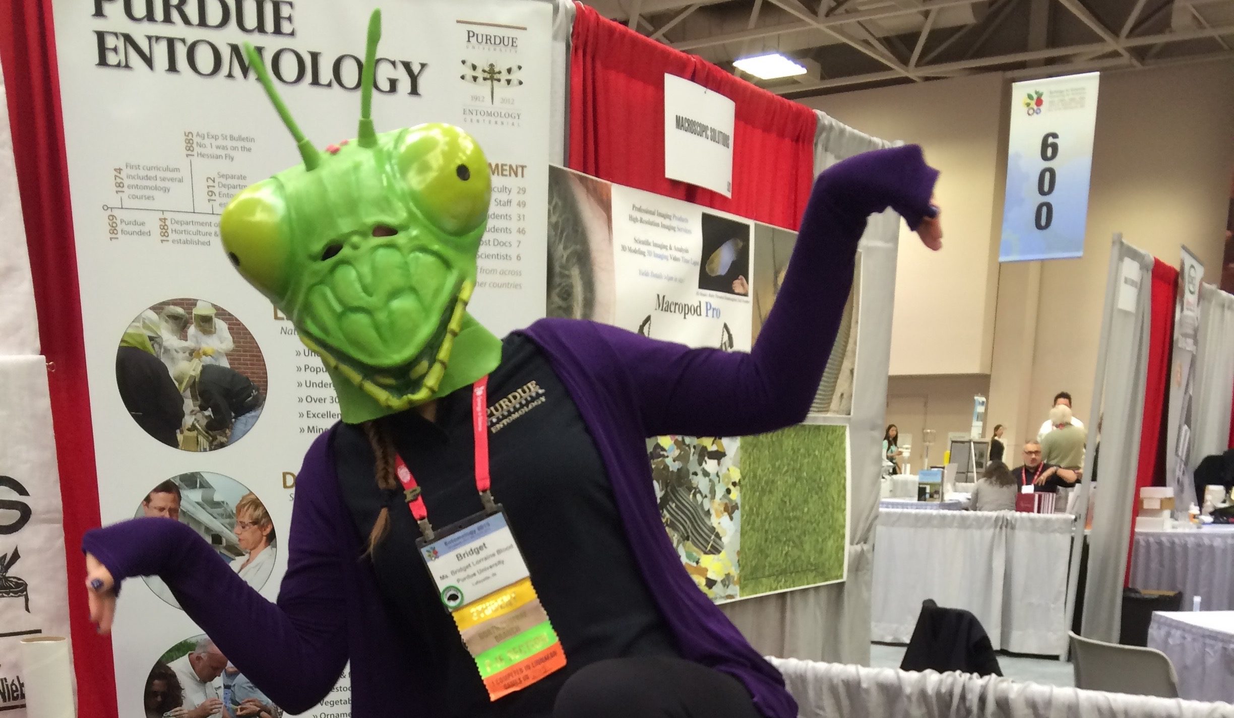 Photo of someone in a mantis mask in front of the purdue entomology booth