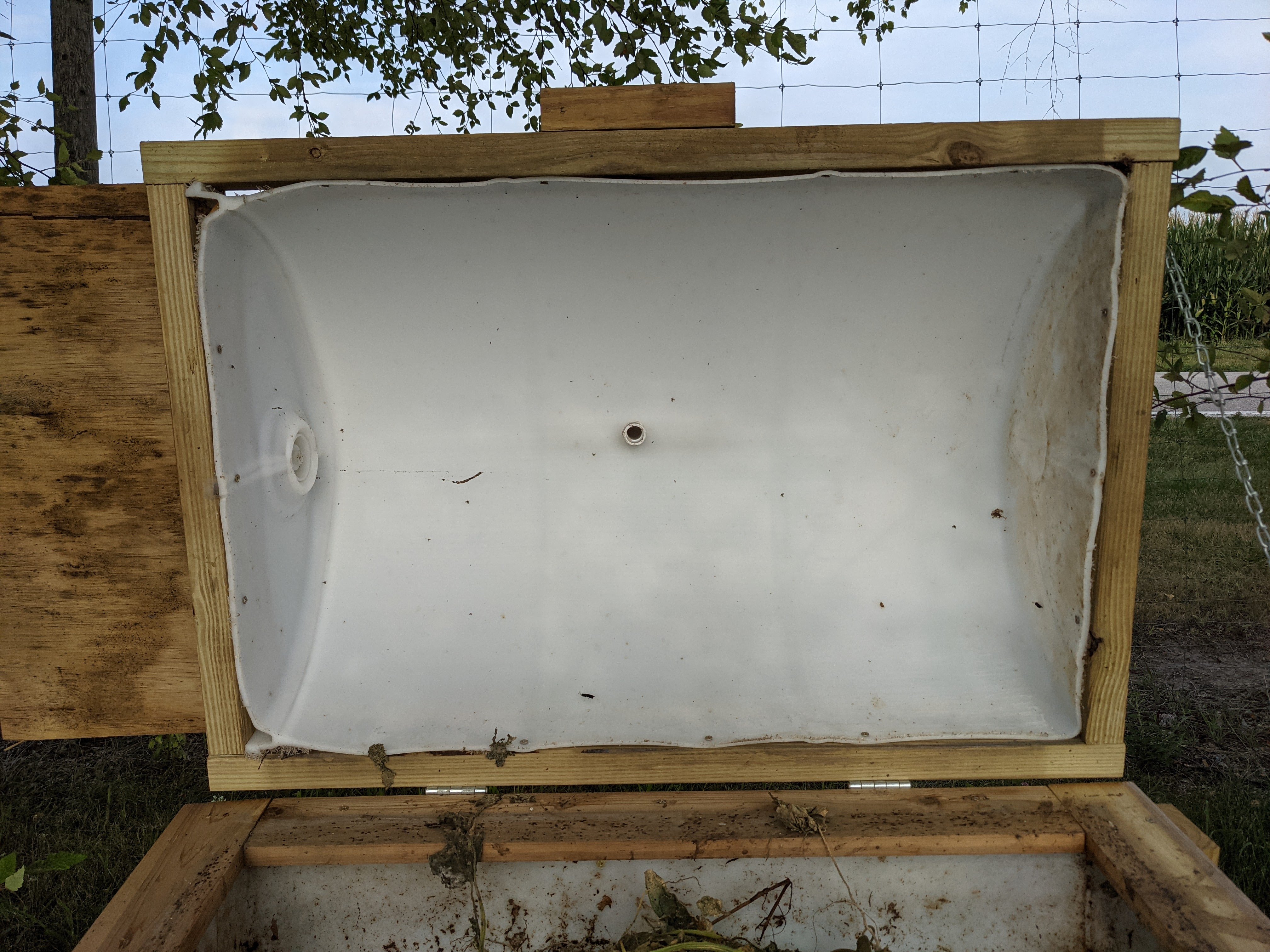 Figure 18: Front view of 55-gallon BSF larval rearing bin, open. Featuring lid with handle and adult entrance hinged to ottom half of rearing bin supported by a chain.  (<em>Photo credit: Catherine Terrell</em>)
