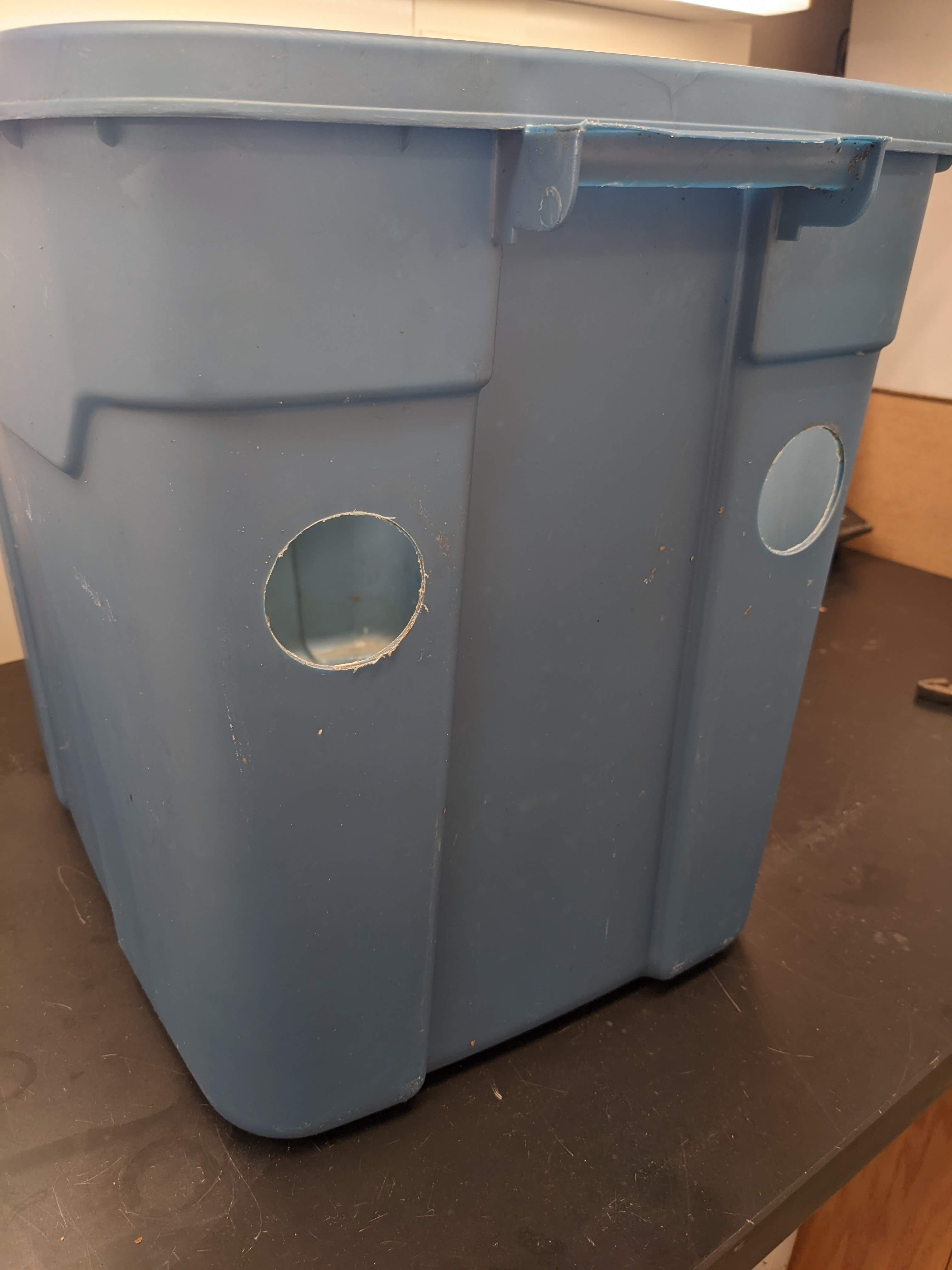 Figure 8. Side view of 18-gallon larval rearing bin showing 1-inch circular openings for PVC pipe to exit rearing bin. (<em>Photo credit: Catherine Terrell</em>)